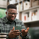 Black man looking confused at his phone.
